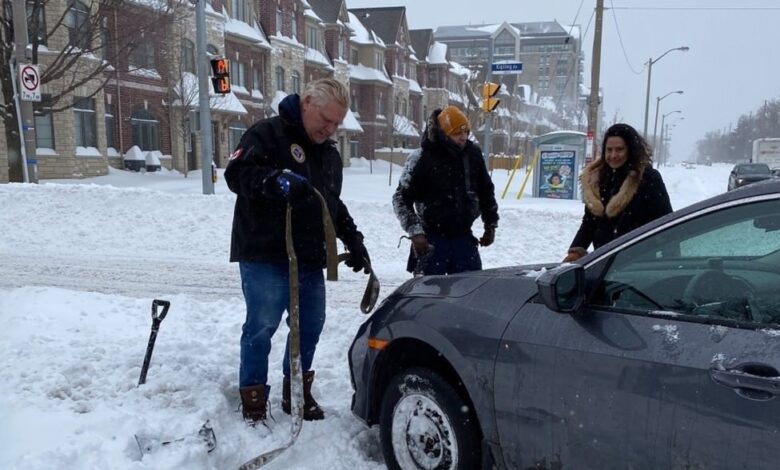 داگ فورد، نخست‌وزیر انتاریو، در حال کمک به سرنشینان یک اتومبیل